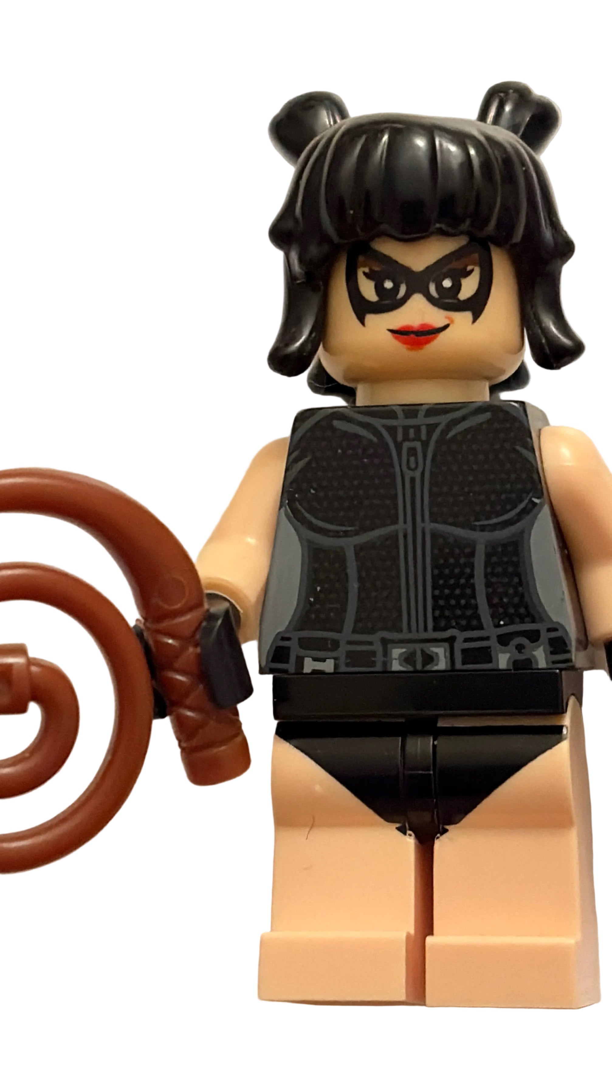 A custom-built female LEGO minifigure with black hair in two buns, a black mask, a black vest, and a brown curly tail accessory, standing against a plain off-white background.