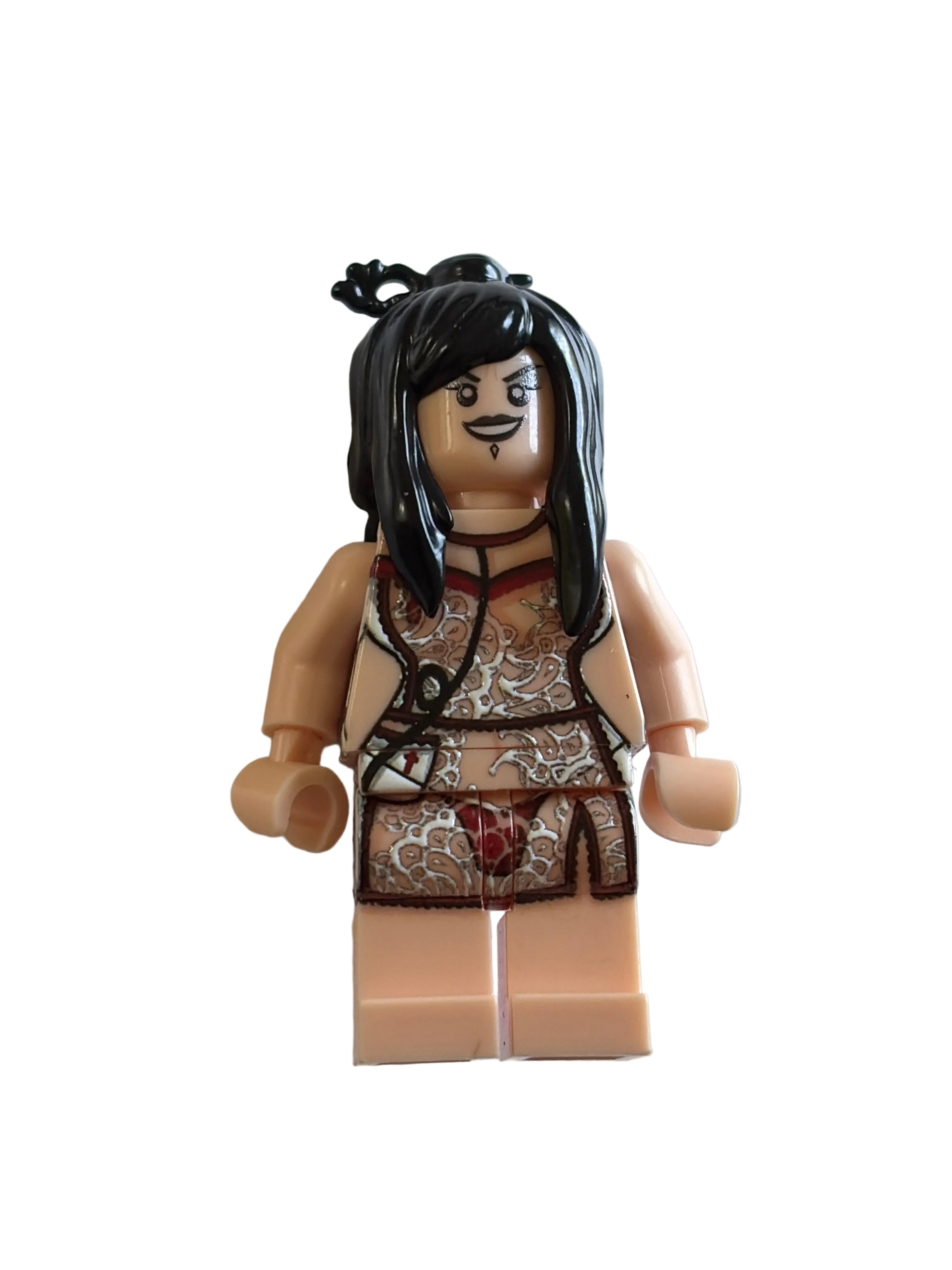 A custom-built female LEGO minifigure with long black hair, a mustache, and a patterned brown and beige top and skirt, standing against a plain light gray wall.