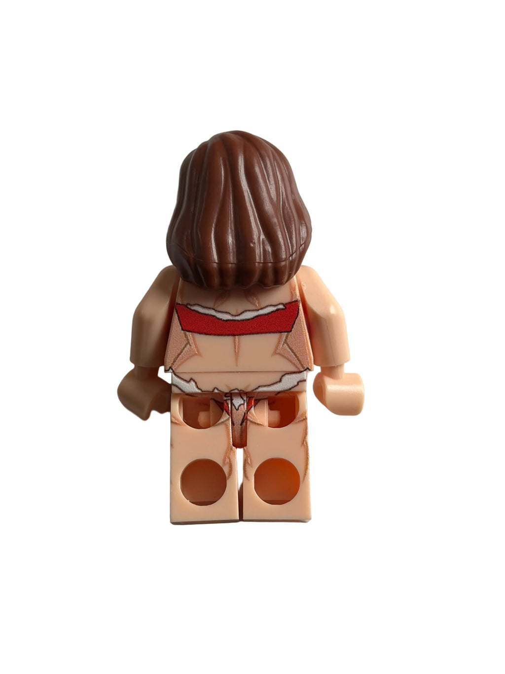 A small printed toy minifigure torso with brown hair, beige skin, and a red-and-white printed torso, photographed on a plain light background.