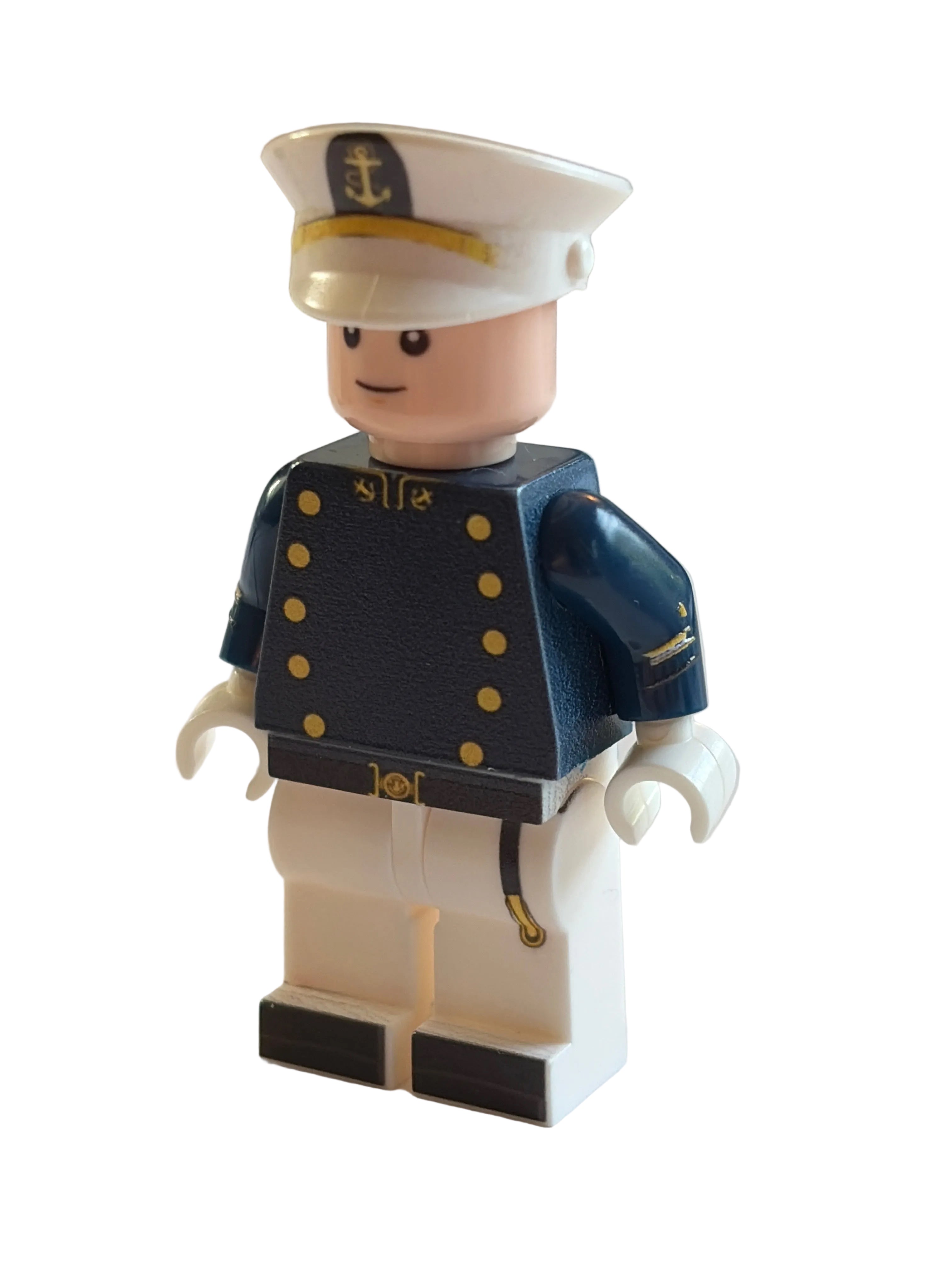 A small toy minifigure dressed in a navy blue military-style uniform with gold buttons and a white hat, mounted against a plain light background.