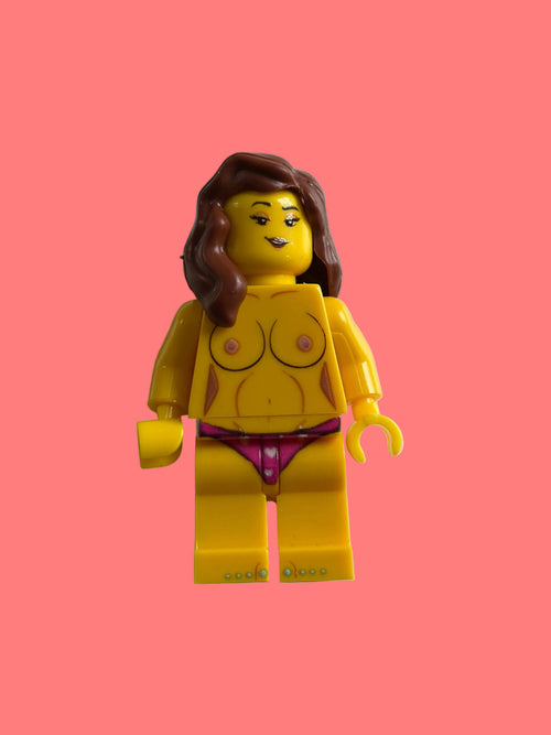 A custom LEGO minifigure of a woman with brown hair, featuring a yellow top with printed bra cups, a purple bikini bottom, and yellow legs, standing against a plain off-white background.