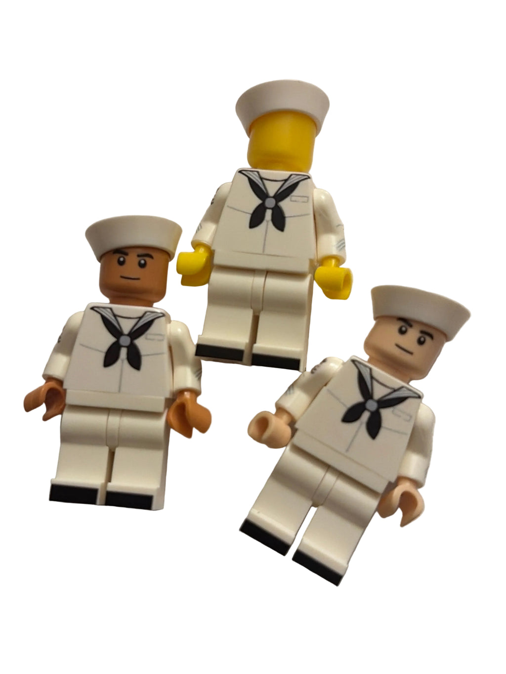 Three Lego-style United States navy enlisted minifigures in white uniforms with black neckties and white hats, arranged on a plain white background.