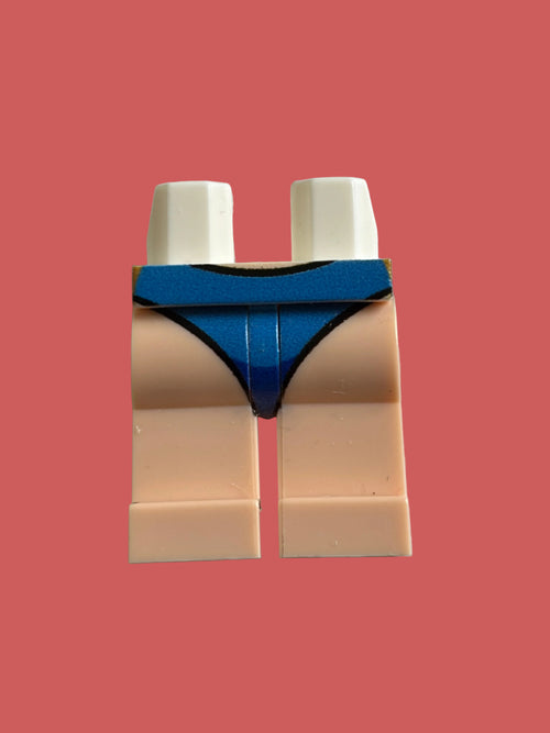 A custom LEGO minifigure leg piece with beige skin-tone legs, white hands, and a blue thong-style undergarment, shown on a neutral light gray background.