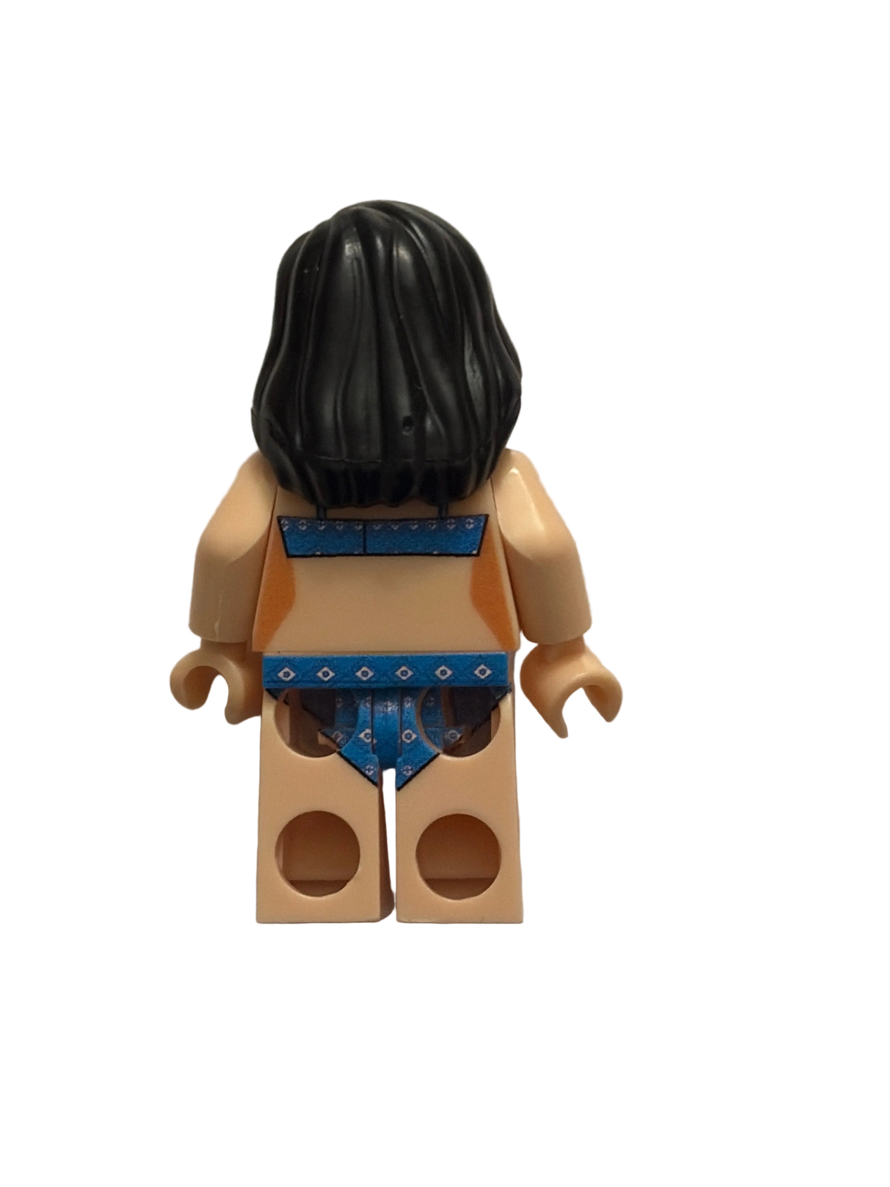 A custom-built toy minifigure torso with black hair, beige skin, and a blue patterned top, photographed from above on a plain off-white surface.