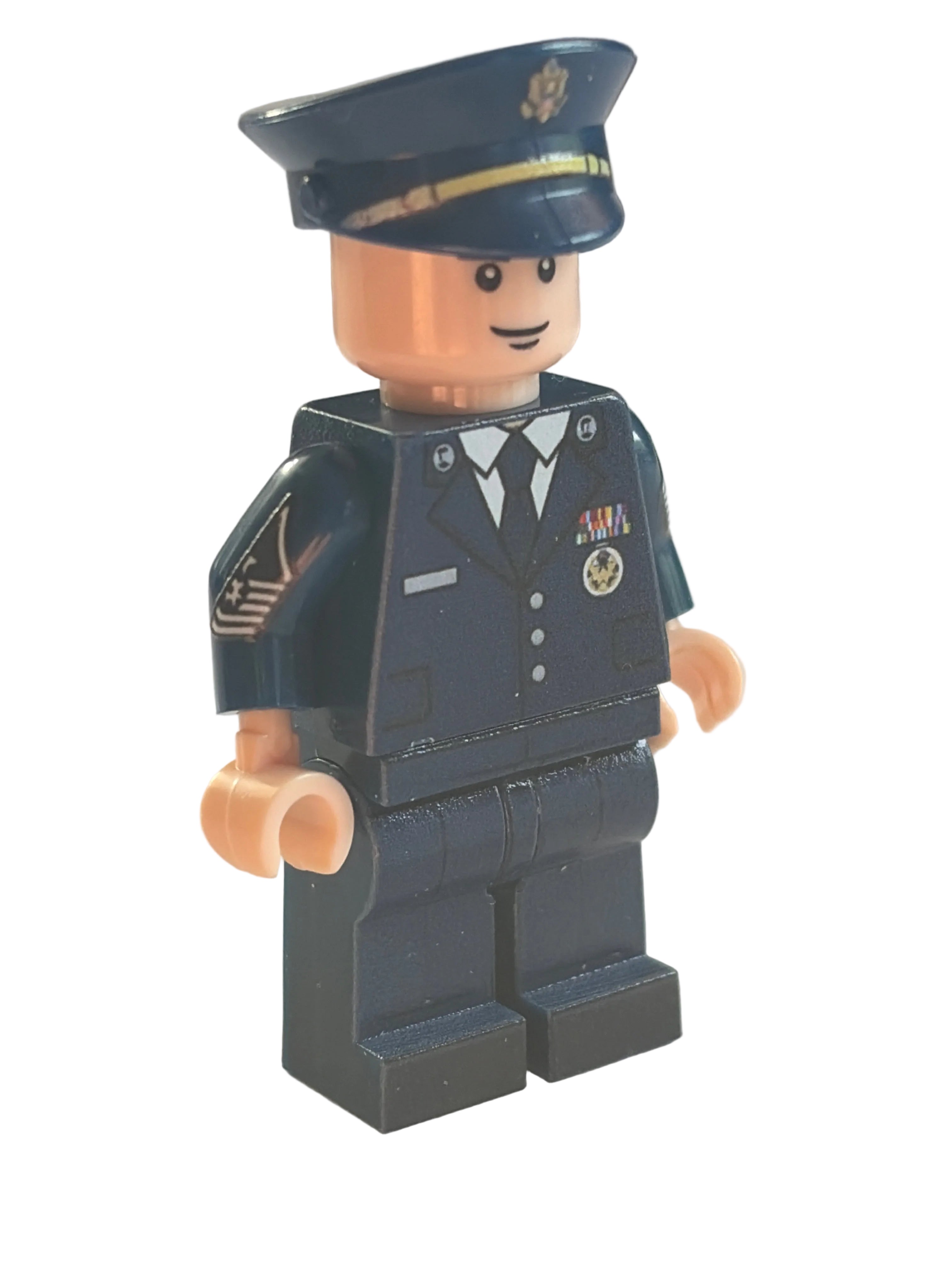 A custom-built toy minifigure resembling a police officer, featuring a dark navy blue uniform with white and gold details, a matching navy blue hat, and tan plastic hands and head, shown against a blurred light background.