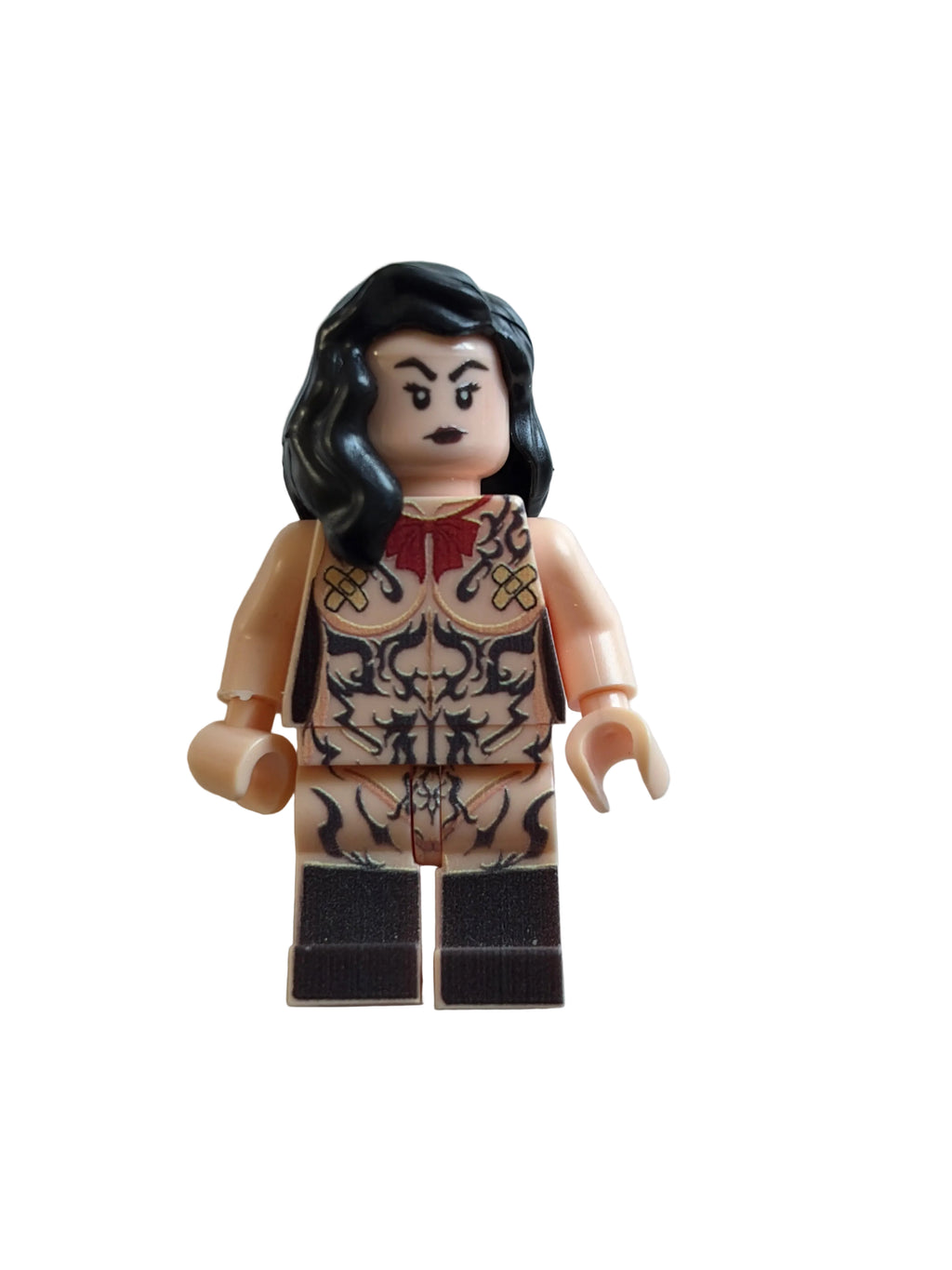 A custom-built LEGO minifigure with black hair, a beige face and hands, a red top, and a black-and-beige patterned skirt, shown on a light gray background.