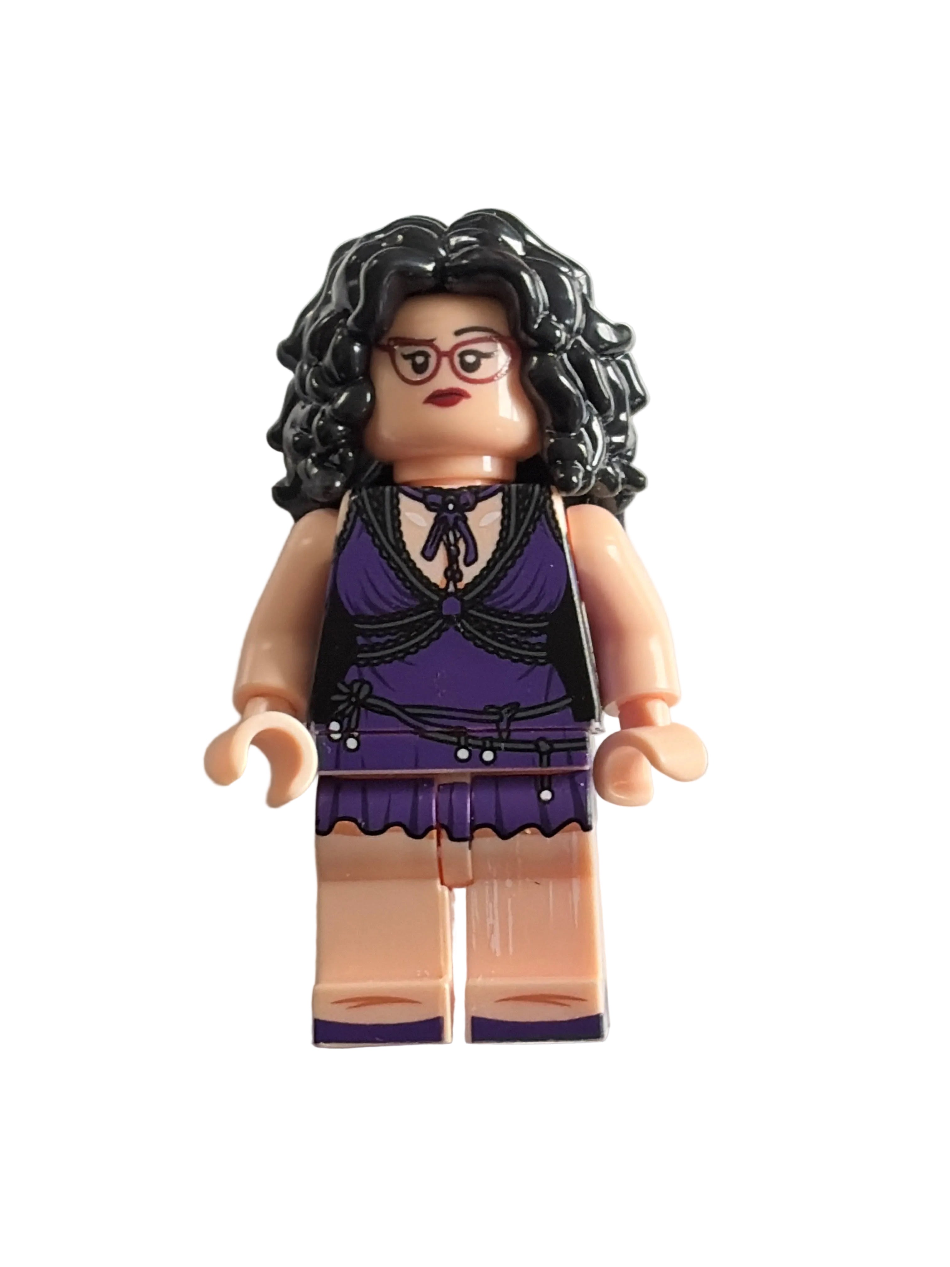 A small toy minifigure with curly black hair, glasses, and a purple-and-black outfit, photographed on a plain light background.