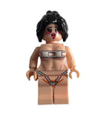 A custom-built female minifigure with black hair, a distressed face, and a beige body, wearing a silver metal collar and a black and white thong with red details, isolated on a white background.