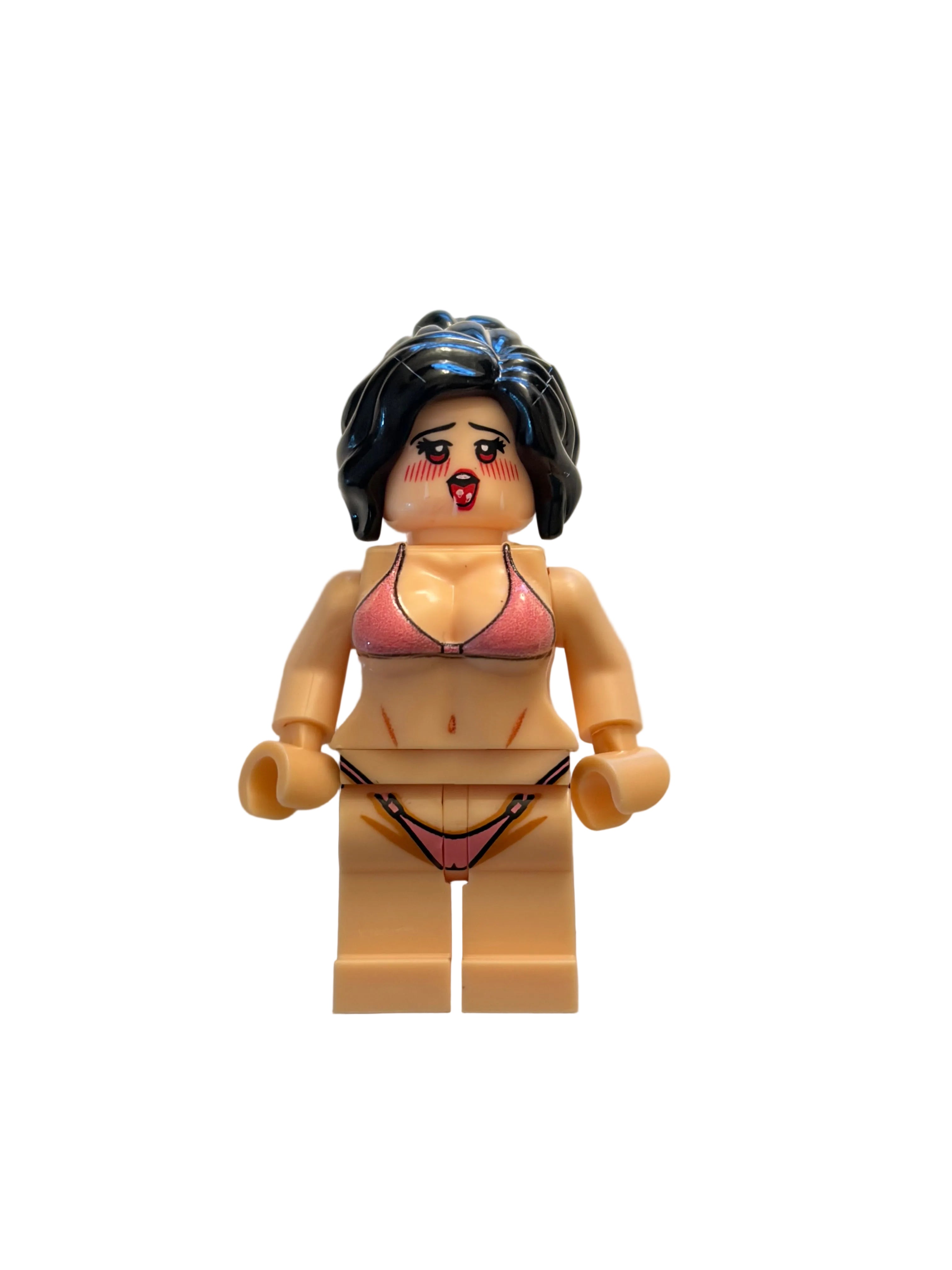 A toy minifigure with dark hair and a pink bikini, positioned horizontally on a plain beige background.