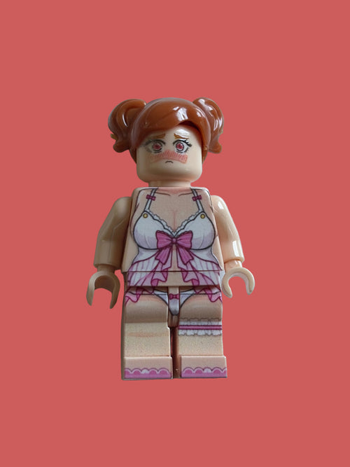 A custom-built toy minifigure with brown hair in pigtails, wearing a pink and white lingerie set, standing against a light blue background.