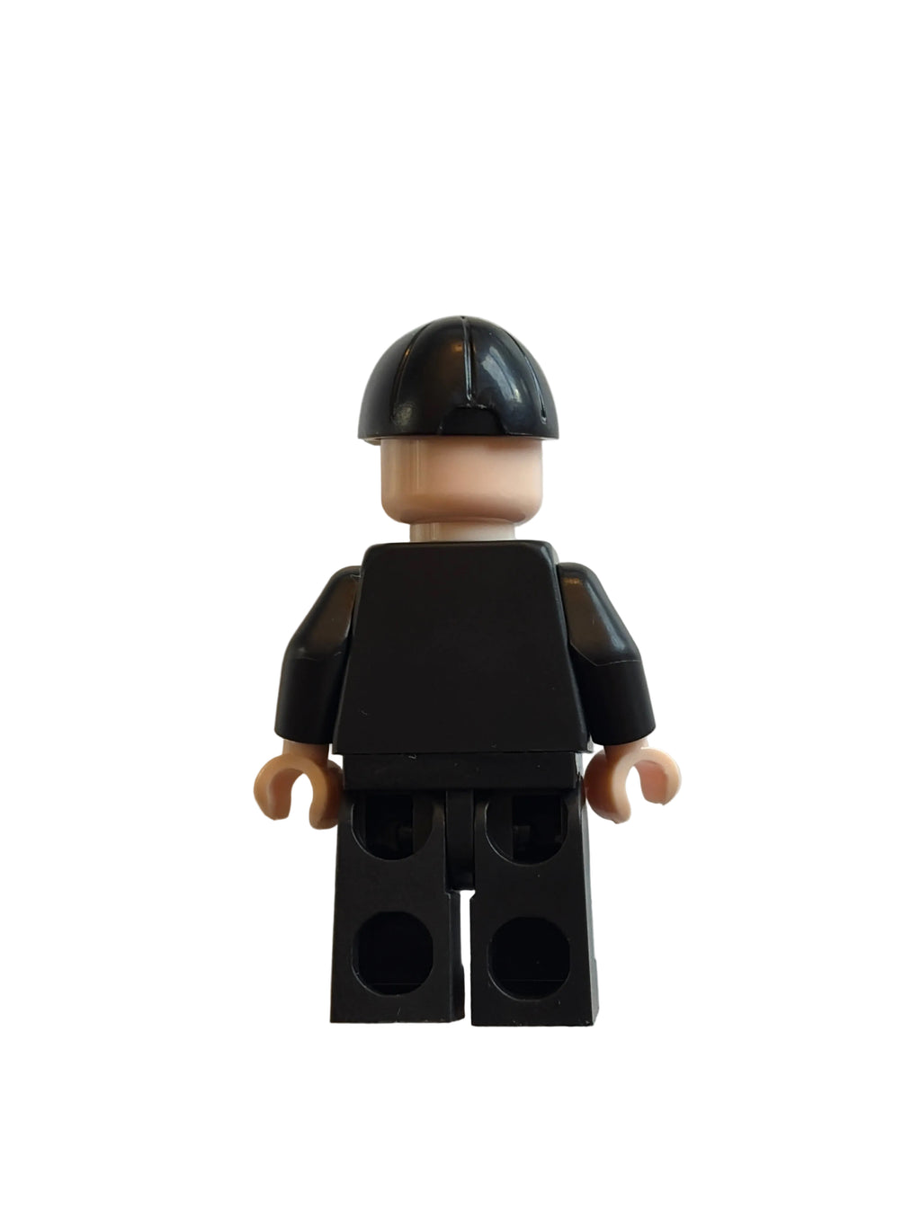 A small black toy minifigure torso with beige hands and a black-and-beige helmet, photographed on a plain off-white background.