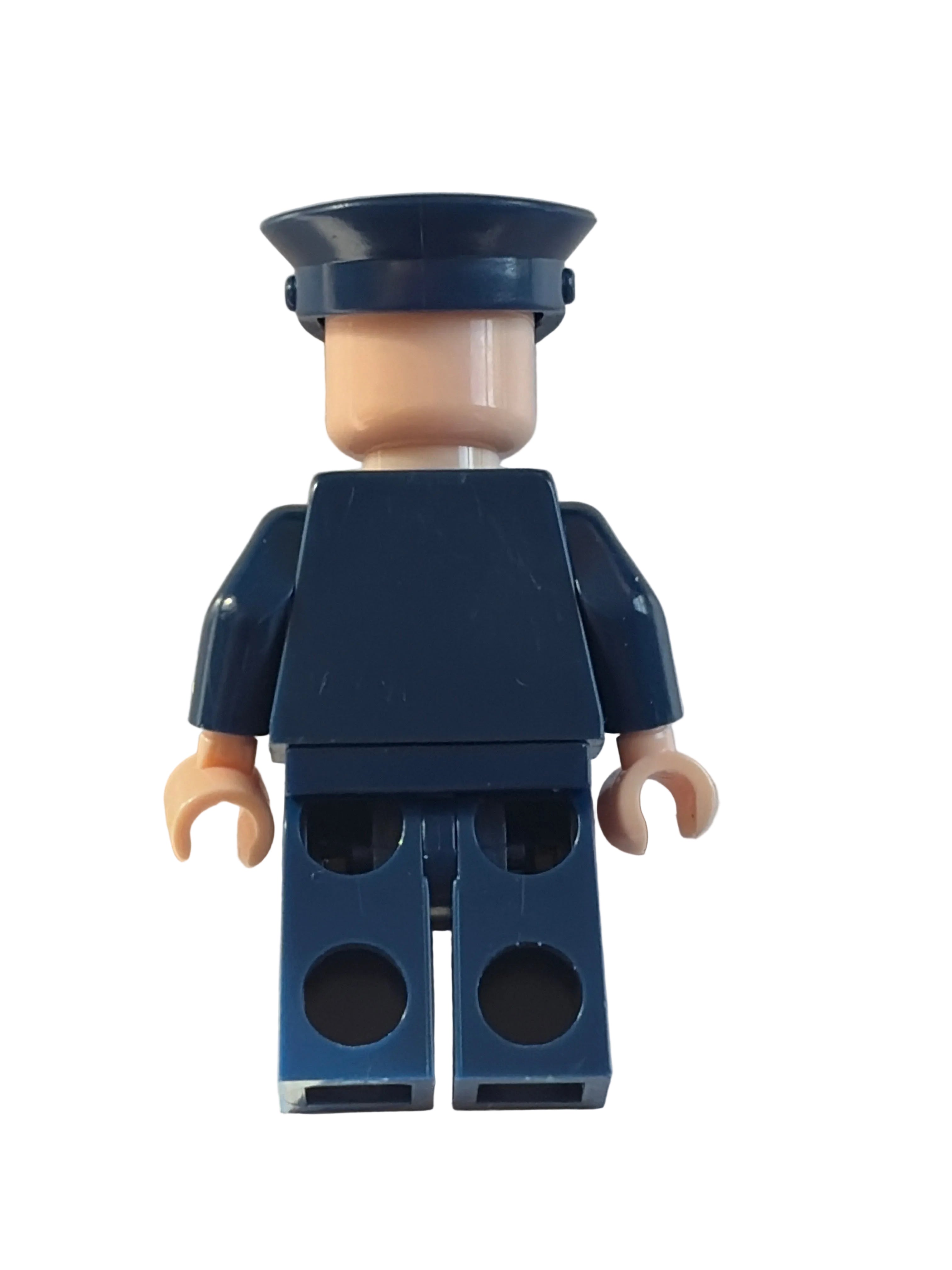 A small toy minifigure torso with dark navy blue arms and back, a beige neck, and peach-colored hands, photographed on a plain light background.