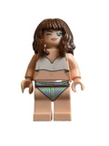 A custom LEGO minifigure torso with brown hair, a beige face and limbs, wearing a white top and a green-gray triangle skirt, lying on a light beige background.