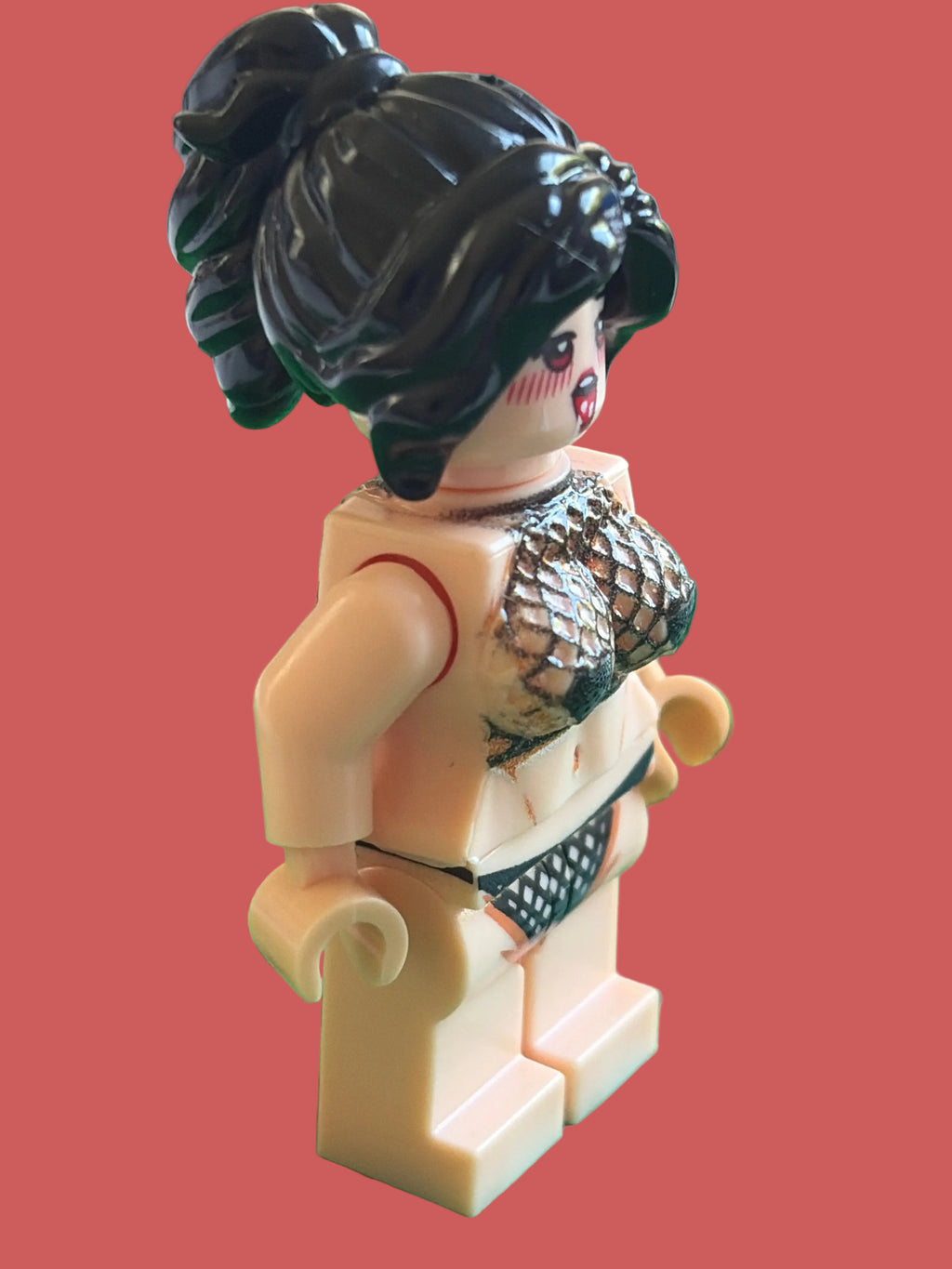 A custom-built female 3D minifigure with black hair in a high ponytail, wearing a fish-scale patterned bikini top and black patterned bikini bottom, on a light pink background.