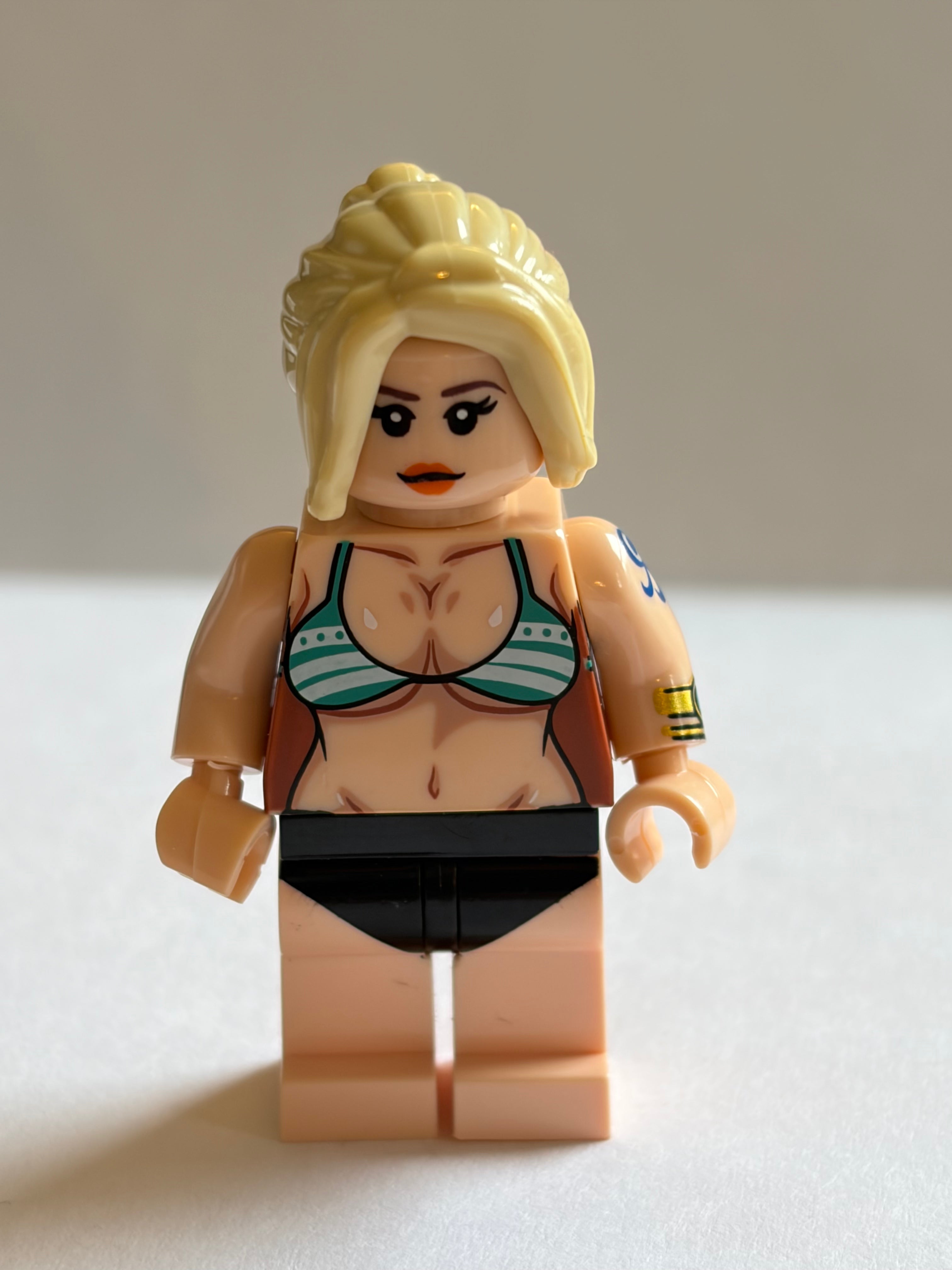 Toy figure of a woman in a bikini with blonde hair on a white background