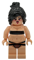 Toy figure with black hair and minimal clothing on a white background