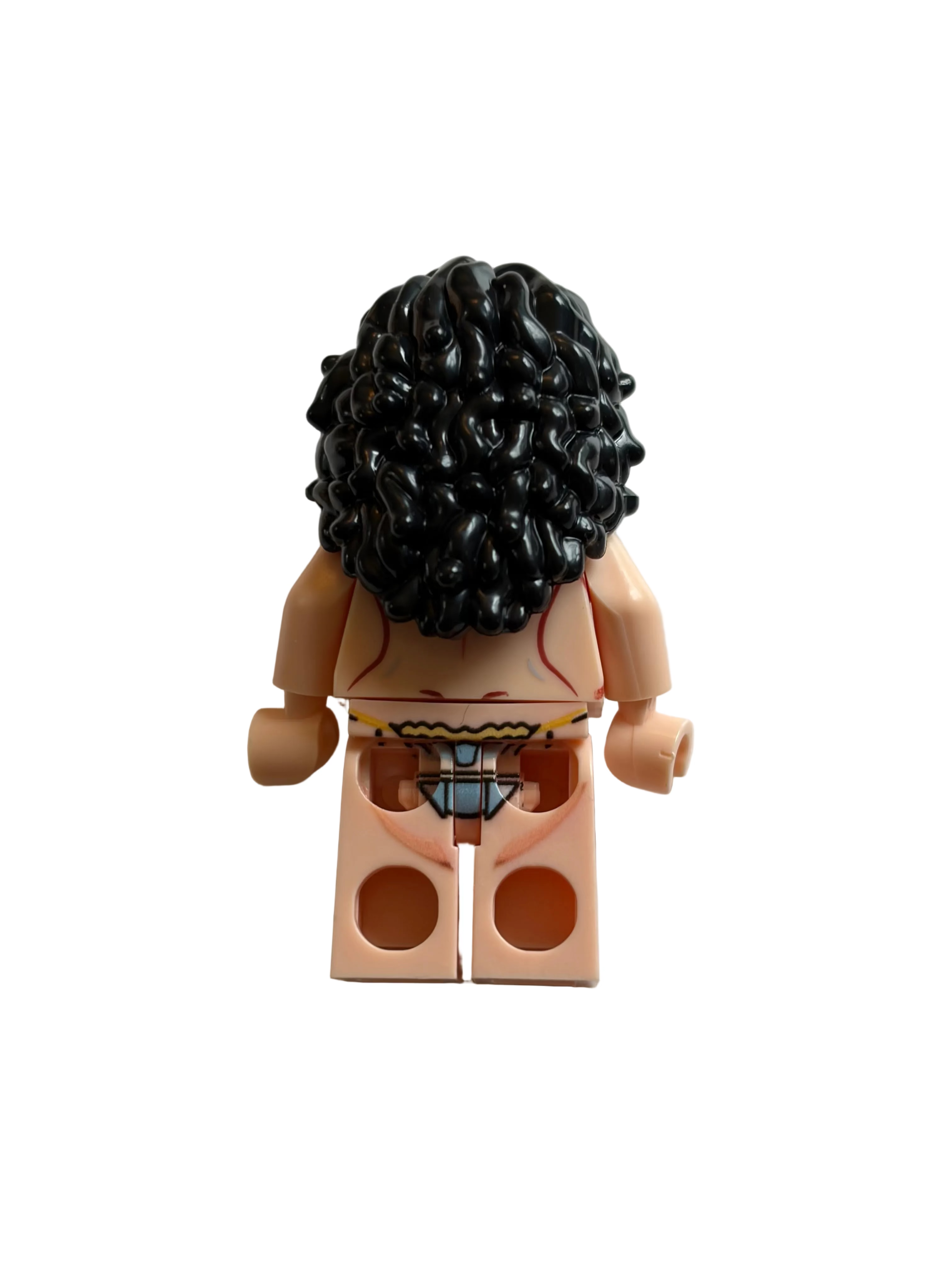 A back view of a custom minifigure with black curly hair, peach skin, and a yellow-and-black patterned waistband, set against a plain light gray background.