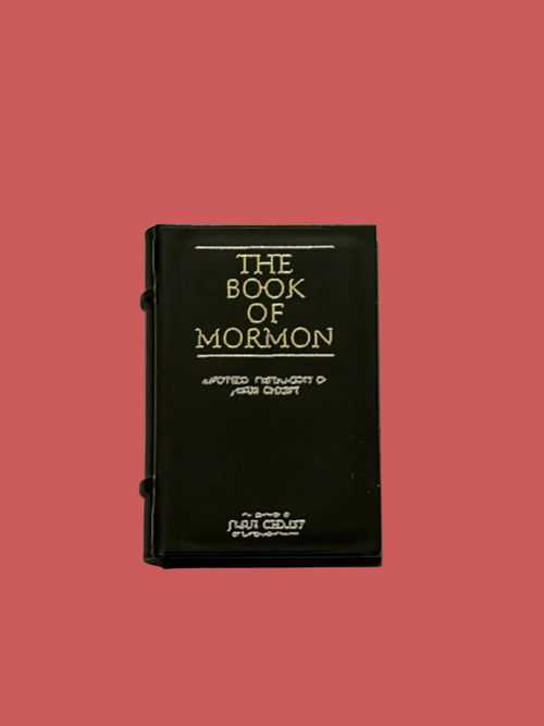 Black minifigure book accessory, Book of Mormon, on light pink background