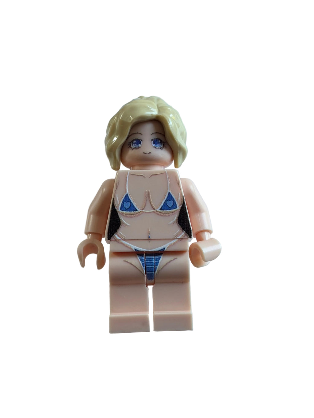 A toy minifigure with blonde hair, blue eyes, and a light flesh skin tone, wearing a blue bikini, lying on a white surface.