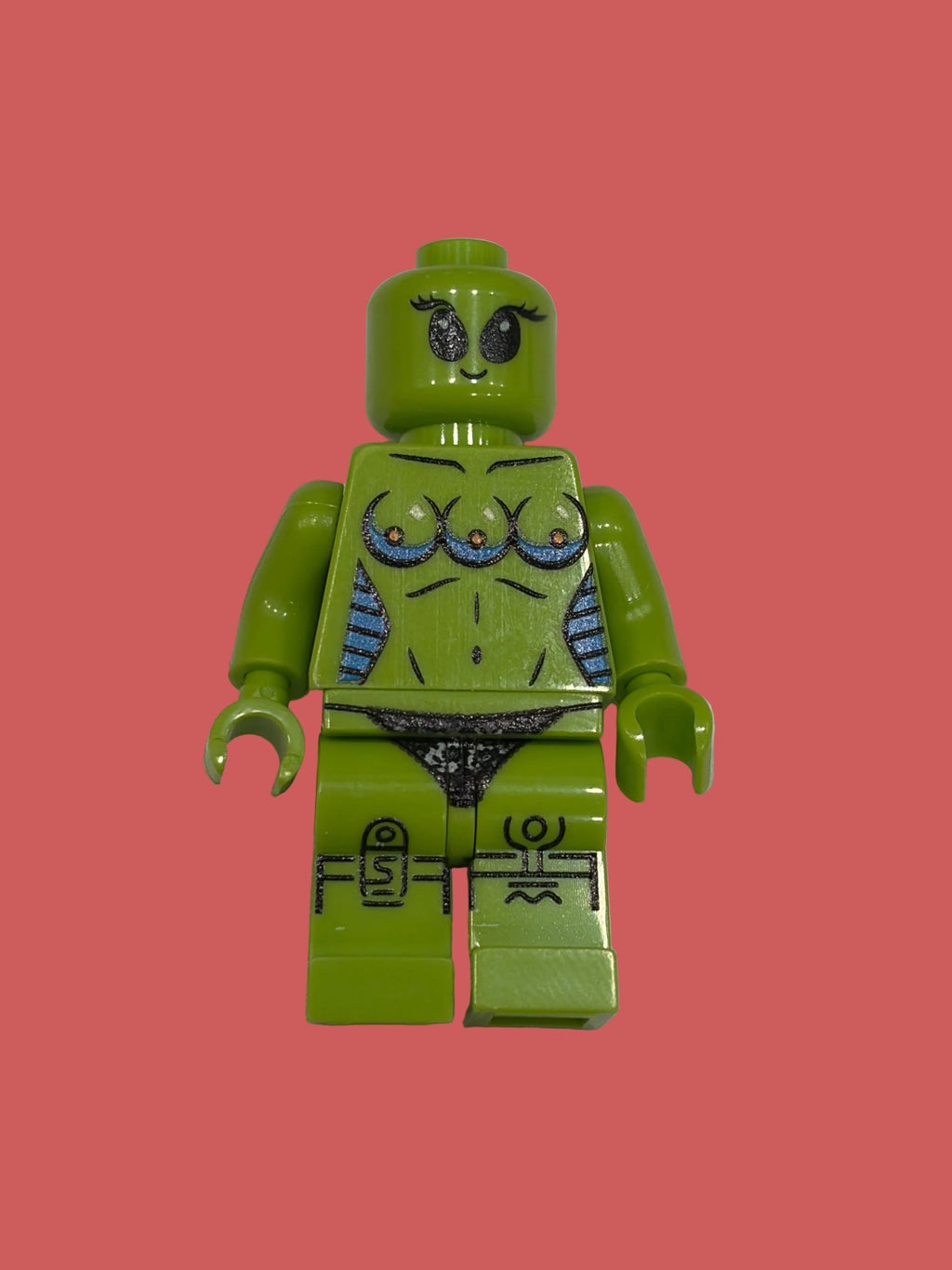 A custom lime green female minifigure with printed blue and black details on her chest and thighs, standing against a plain off-white background.