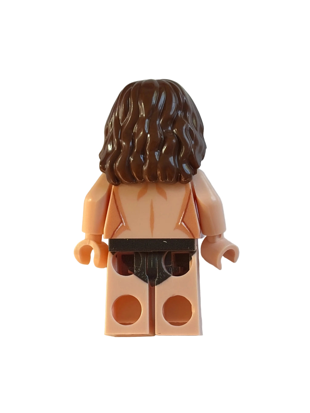 A small plastic toy minifigure torso with dark brown hair, peach skin, and a black belt, photographed on a plain light background.