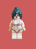 A custom-built female minifigure with messy black hair, wearing a pink and black bikini, standing on a light pink background
